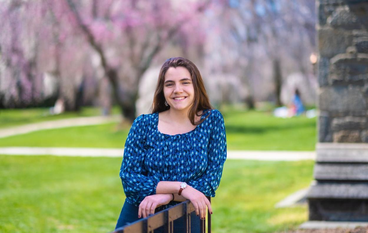 Charlotte McDermott posing with cherry blossoms in the background